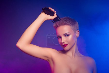Téléchargez les photos : Photo de fille utilisant un équipement professionnel de coiffeur rasage coupe de cheveux sur fond ultraviolet brouillard. - en image libre de droit