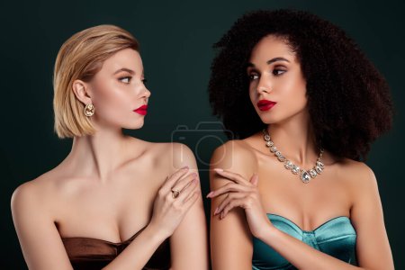 Photo for Photo of attractive girls look each other touch tender gentle arm skin isolated dark green color background. - Royalty Free Image
