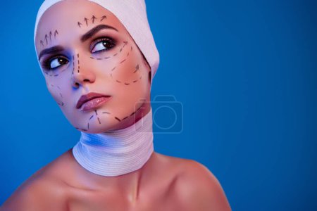 Foto de Foto de chica atractiva cirugía plástica paciente con dibujo marcas de corrección facial mirada en el color de fondo de neón. - Imagen libre de derechos