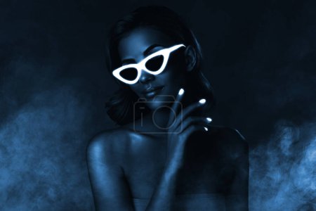 Téléchargez les photos : Collage 3d image de cool jolie dame porter des lunettes de soleil incandescentes boîte de nuit clubbing brouillard bleu fond sombre. - en image libre de droit