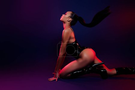 Photo for Photo of girl stretching back dance movements wear black leather suit boots isolated neon multicolor background. - Royalty Free Image