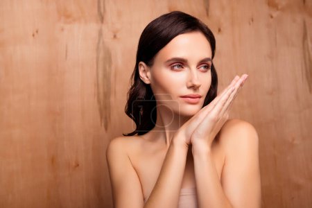 Photo for Photo of brunette hair woman look empty space with hands together isolated brown color background. - Royalty Free Image