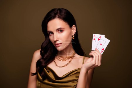Téléchargez les photos : Photo de dame rusée bluff tenant des cartes de poker pleine victoire de la maison au casino sur fond de couleur brune. - en image libre de droit