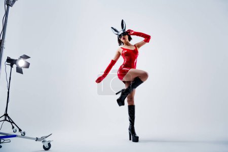 Photo for Full size photo of attractive woman dancing have fun rabbit mask red leather clothes isolated on light gray background. - Royalty Free Image