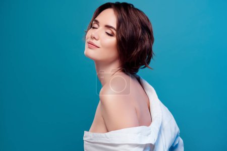 Photo for Portrait of lovely dreamy girlfriend with bare shoulder wearing white seductive shirt isolated on blue color background. - Royalty Free Image