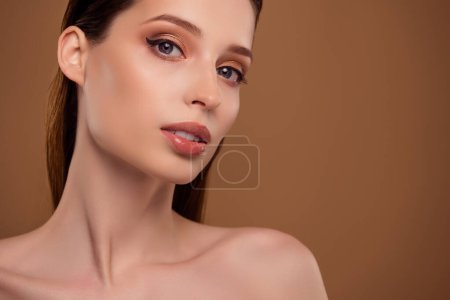 Téléchargez les photos : Photo de femme adorable brillante épaules nues bénéficiant d'un maquillage naturel espace vide isolé fond de couleur beige. - en image libre de droit