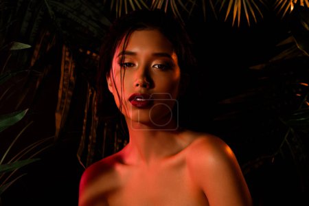 Téléchargez les photos : Photo de fille coréenne asiatique avec maquillage regarder sous néon lumière orange. - en image libre de droit
