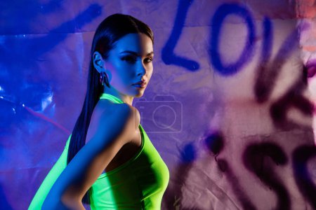 Téléchargez les photos : Portrait de profil de jolie fille modèle chic posant bannière studio multicolore vif fond clair néon. - en image libre de droit