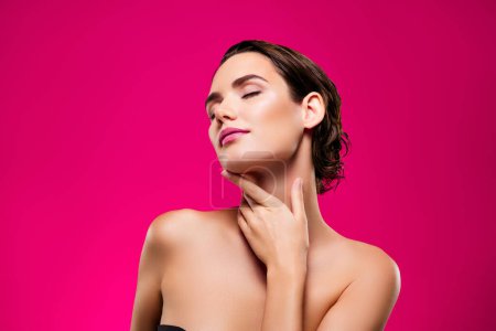 Foto de Foto de atractiva joven mujer tacto cuello suave cuidado de la piel rutinario hombros aislados sobre fondo de color rosa. - Imagen libre de derechos