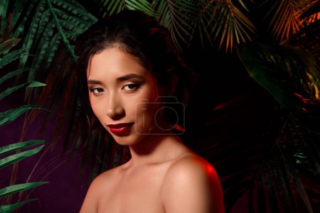 Photo for Photo of mongolian korean girl with bronze tone tanned skin near exotic palm trees. - Royalty Free Image