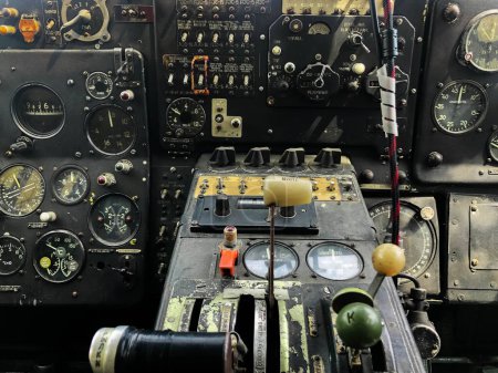 Das Cockpit-Bedienfeld des alten Flugzeugs schließt sich. Detail eines alten Flugzeugcockpits mit verschiedenen Indikatoren, Knöpfen und Instrumenten. Viele Knöpfe und Hebel auf dem Flugzeugsteuerpult.