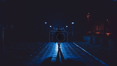 Foto de Male detective in a hat and raincoat at night in a rainy city in the style of film noir - Imagen libre de derechos