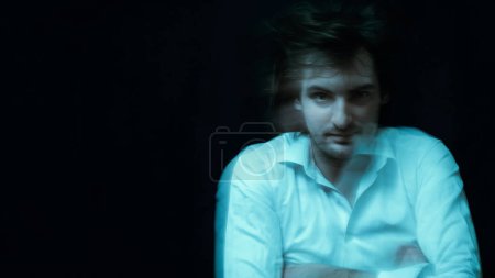 retrato esquizofrénico del hombre con trastornos mentales y enfermedades mentales en camisa de fuerza sobre fondo oscuro