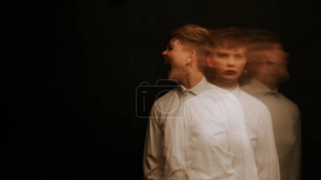 Téléchargez les photos : Psychopath with mental disorders and insanity on a dark background. A blurry portrait of a woman in a straitjacket - en image libre de droit