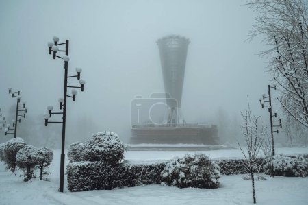 Téléchargez les photos : SHYMKENT, KAZAKHSTAN - 19 DÉCEMBRE 2023 : Monument Altyn Shanyrak dans le parc de l'Indépendance à la place Ordabasy dans la ville de Shymkent au Kazakhstan en hiver avec neige et brouillard - en image libre de droit