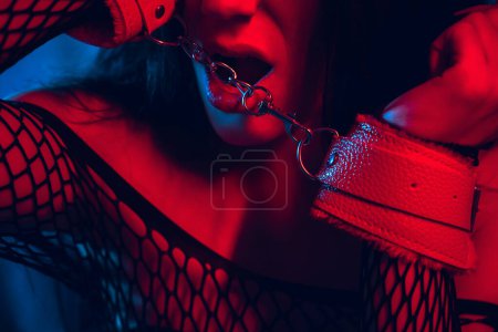 Foto de Retrato de una mujer sumisa sexy con las manos en cuero esposas BDSM. Esclava de abajo en ropa interior en la cama. Sexo con sumisión y dominación - Imagen libre de derechos