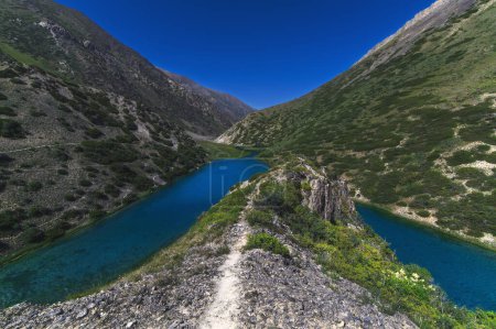 Photo for Lake with blue clear clear water in the mountains in summer. Koksai Ainakol Lake in Tien Shan Mountains in Asia in Kazakhstan - Royalty Free Image