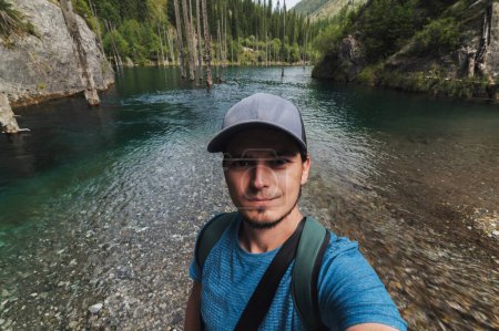 Téléchargez les photos : Selfie d'un touriste masculin au lac Kaindy dans les montagnes Tien Shan au Kazakhstan en été - en image libre de droit