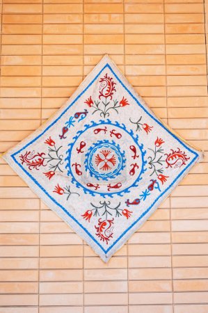Alter weißer Teppich mit traditionellem arabischen usbekischen Muster an der Wand in Usbekistan