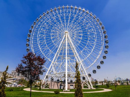 white big ferris wheel on background a blue sky in Navruz Park in Tashkent in Uzbekistan in summer