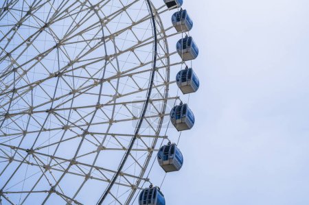 blanc grande roue Ferris sur fond un ciel dans le parc d'attractions à la foire en été