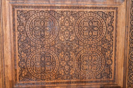 traditional oriental Tajik patterns arabesque ornament in kandakori bagdadi style on an ancient wooden carved door in Tadjikistan