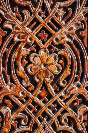 Oriental tajik Islamic kandakori patterns ornament on an ancient wooden carved door in Tajikistan close-up