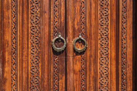 traditional oriental Uzbek Islamic patterns arabesque ornament on an ancient wooden carved door in Uzbekistan close-up