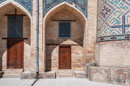 Uzbek carved wooden doors to Kukeldash Madrasah with a traditional pattern decorated with oriental arabic carved ornaments in Uzbekistan in Tashkent