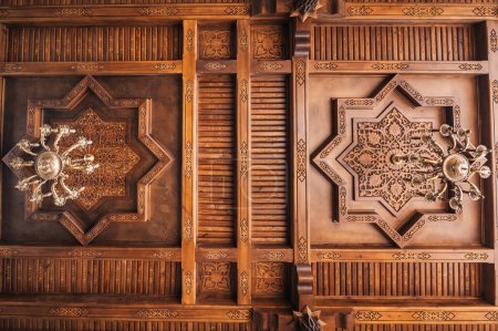 wooden carved ceiling with traditional oriental Uzbek carved pattern decorated Asian ornaments with chandeliers in Uzbekistan in Tashkent