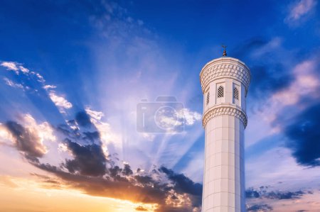 marble white minaret of new Minor Mosque in Tashkent in Uzbekistan on background of the beautiful blue sunset sky