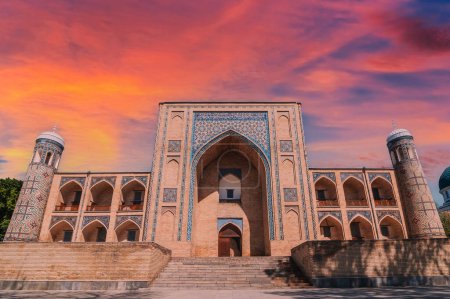 facade of the ancient Uzbek Islamic Kukeldash madrassah in Tashkent in Uzbekistan. Old stone medieval oriental madrasah in Asia at sunset