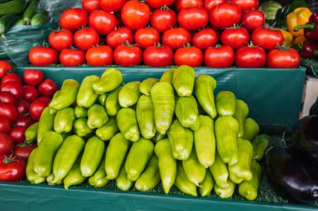 counter with fresh vegetables at a grocery farmers market. Tomatoes and peppers on store shelves