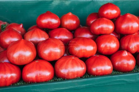 stall with fresh red tomatoes on the counter at the farmers market. Tomatoes on grocery store shelf