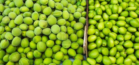 Téléchargez les photos : Abricot vert immature sur le comptoir du bazar. Nourriture traditionnelle en Asie centrale en Ouzbékistan et au Tadjikistan - uryuk vert, dovcha, gura - en image libre de droit