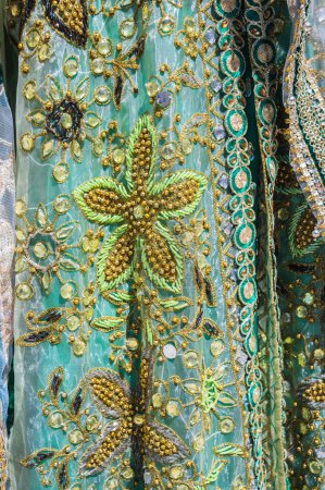 beaded embroidery on decorated traditional asian wedding dress close-up