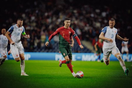 Foto de Cristiano Ronaldo, Denis Vavro durante el partido de clasificación de la UEFA Euro 2024 entre las selecciones nacionales de Portugal y Eslovaquia en el Estadio do Dragao, Oporto. (Maciej Rogowski) - Imagen libre de derechos