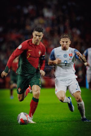 Foto de Cristiano Ronaldo, Tomas Suslov durante el partido de clasificación de la UEFA Euro 2024 entre las selecciones nacionales de Portugal y Eslovaquia en el Estadio do Dragao, Oporto. (Maciej Rogowski) - Imagen libre de derechos