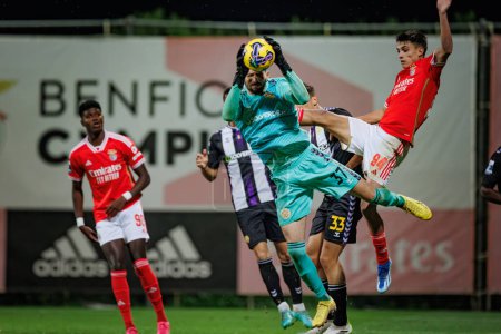 Photo for Lucas Oliveira (goalkeeper) catches the ball between Benfica defenders during Liga Portugal 2 Sabseg 23/24 game between SL Benfica B and CD Nacional at Benfica Campus, Seixal, Lisbon, Portugal. (Maciej Rogowski) - Royalty Free Image