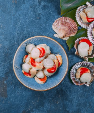 Téléchargez les photos : Pétoncles de fruits de mer frais crus sur fond bleu
. - en image libre de droit