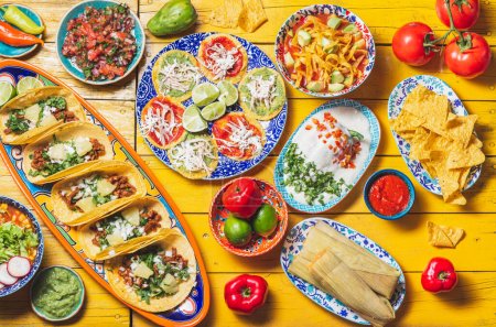 Photo for Mexican festive food for independence day - independencia chiles en nogada, tacos al pastor, chalupas pozole, tamales, chicken with mole poblano sauce. Yellow background - Royalty Free Image
