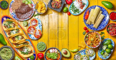 Photo for Mexican festive food for independence day - independencia chiles en nogada, tacos al pastor, chalupas pozole, tamales, chicken with mole poblano sauce. Yellow background - Royalty Free Image