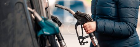 Photo for High prices of petrol and diesel fuel ath the petrol station, young woman refueling a car, economic crisis concept - Royalty Free Image