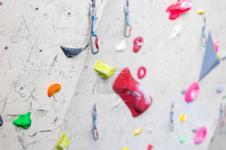 Photo for Close up of indoor climbing wall with carbines and colored grips fix it on a wall, concept of climbing - Royalty Free Image