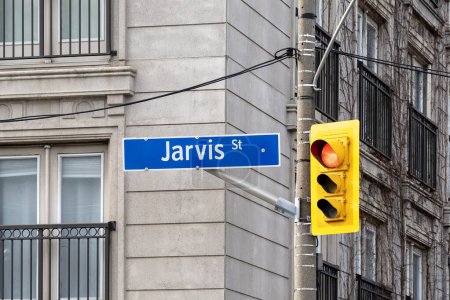 Téléchargez les photos : Toronto, Canada - Le 9 novembre 2020 : Une pancarte de la rue Jarvis avec feu de signalisation est visible au centre-ville de Toronto, au Canada. Jarvis Street est une artère nord-sud à Toronto. - en image libre de droit