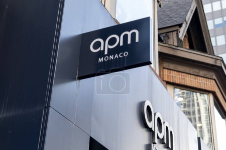 Foto de Toronto, Canadá - 20 de noviembre de 2020: Un primer plano del letrero colgante de la tienda APM Monaco se ve en Toronto, Canadá. APM Monaco es una empresa de joyería de moda. - Imagen libre de derechos