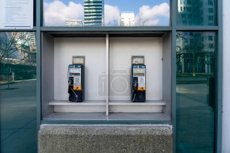 Téléchargez les photos : Toronto, Canada - Le 28 novembre 2020 : Deux vieux téléphones publics à cloche avec de la poussière sur eux au centre-ville de Toronto, Canada. La disparition des téléphones payants est un résultat peu surprenant des téléphones cellulaires. - en image libre de droit