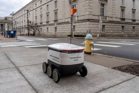 Téléchargez les photos : Un robot de livraison de nourriture Starship conduira sur le trottoir du campus de l'Université de Pittsburgh à Pittsburgh, Pennsylvanie, États-Unis, le 11 janvier 2020. Les robots livrent de la nourriture de quatre restaurants du campus. - en image libre de droit
