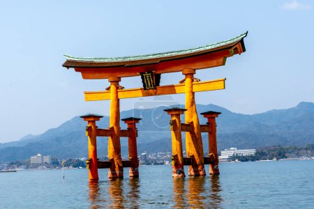 Photo for Floating torii gate in the water at Itsukushima Shrine (gate sign reads Itsukushima Shrine) in Hiroshima, Japan. The shrine complex is listed as a UNESCO World Heritage Site. - Royalty Free Image