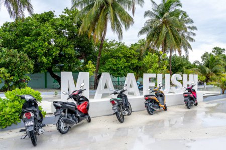 Téléchargez les photos : Maafushi, Maldives - 29 novembre 2018 : Panneau Maafushi avec des motos devant. Maafushi Island est l'une des plus grandes îles des Maldives. - en image libre de droit